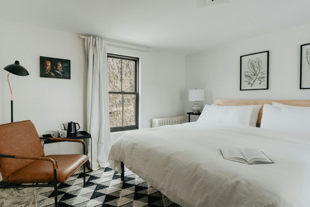 Sypialnia z białym łóżkiem i materacem na wymiar i czarno-białą podłogą w kratkę